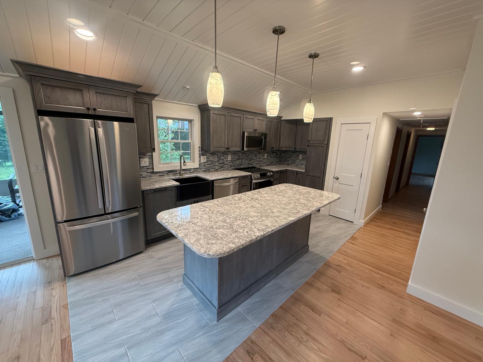Stained custom cabinetry with crown molding and tile backsplash