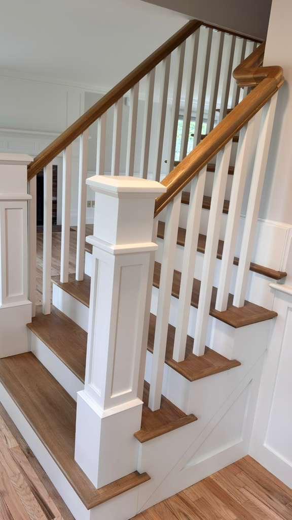 Custom newel post with painted wainscot and oak handrail