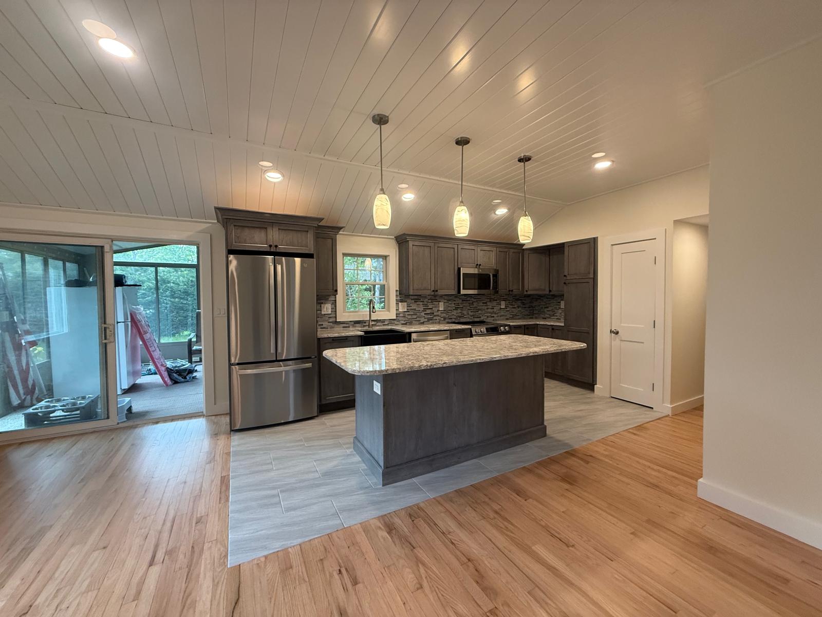 Living area opening to kitchen — new red oak hardwood floors