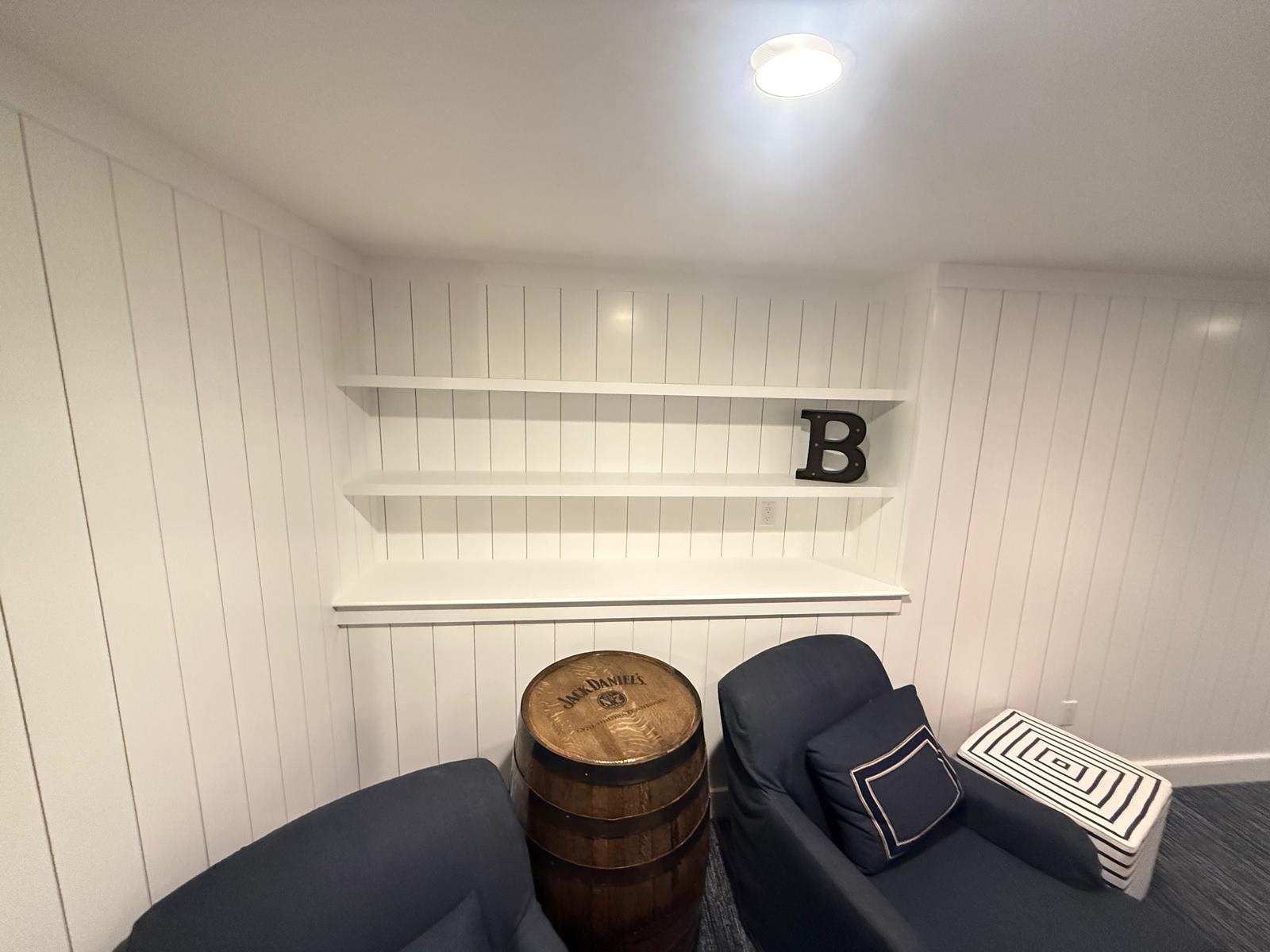 Custom built-in floating shelves on shiplap feature wall