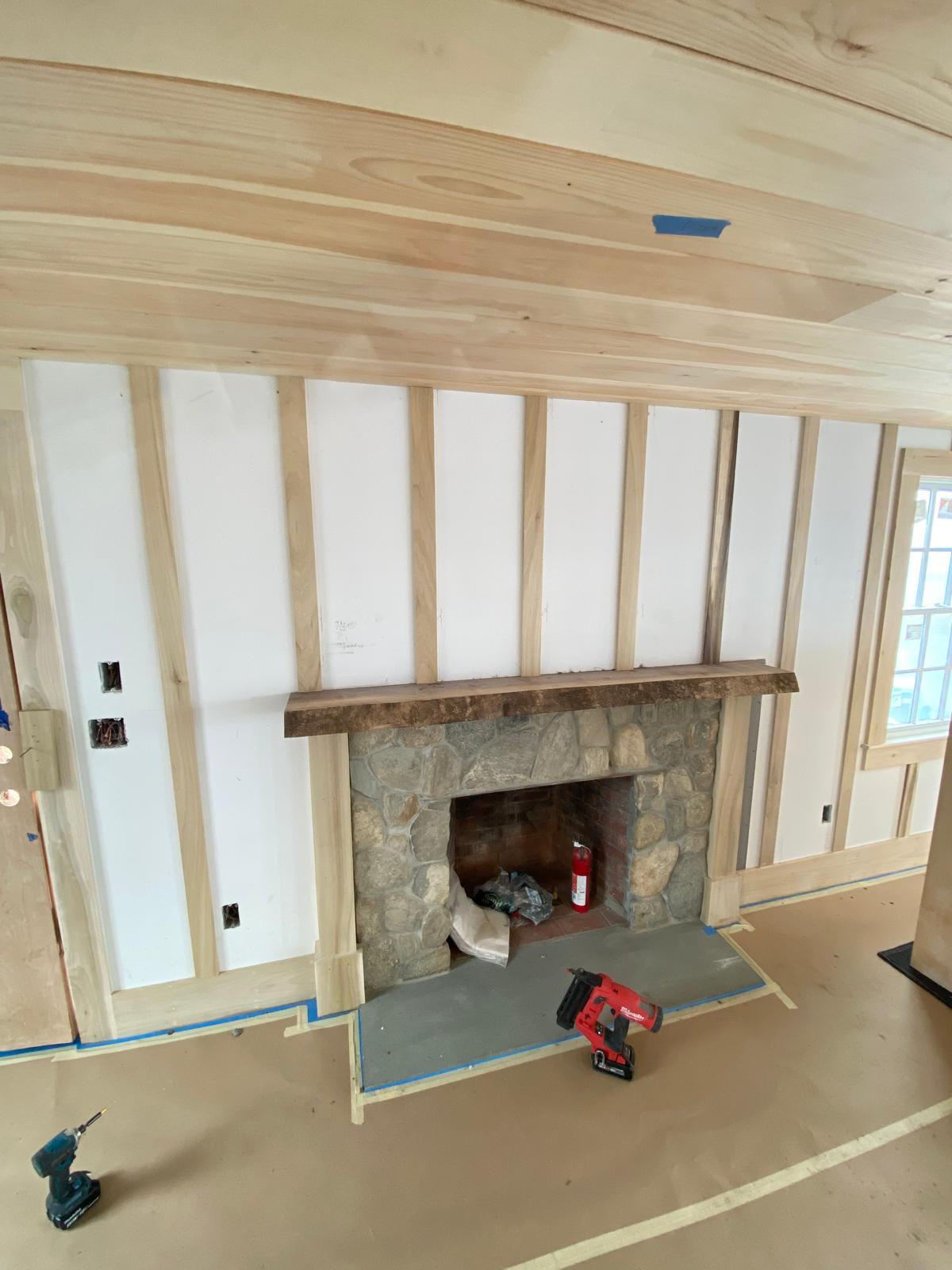 Board-and-batten framing installed around the stone fireplace