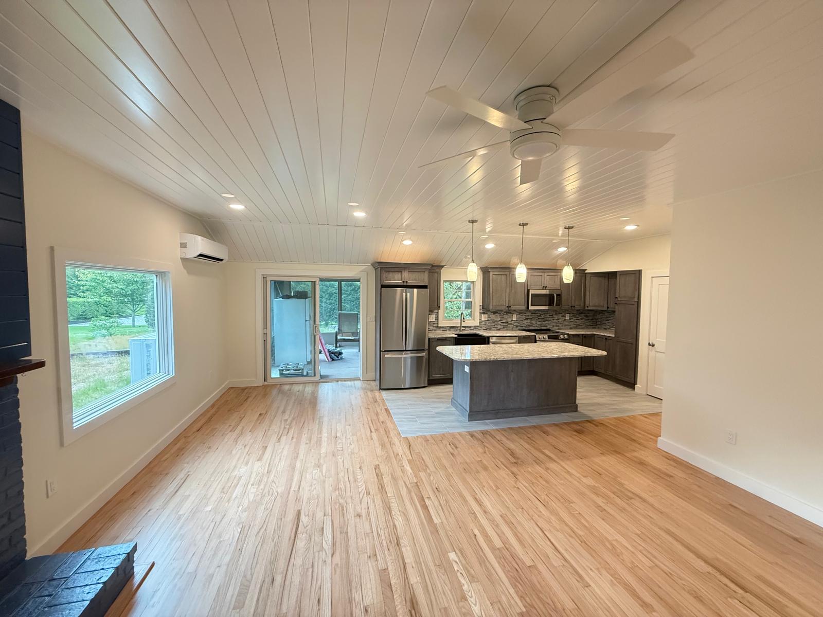 Open-concept kitchen with vaulted shiplap ceiling and custom island